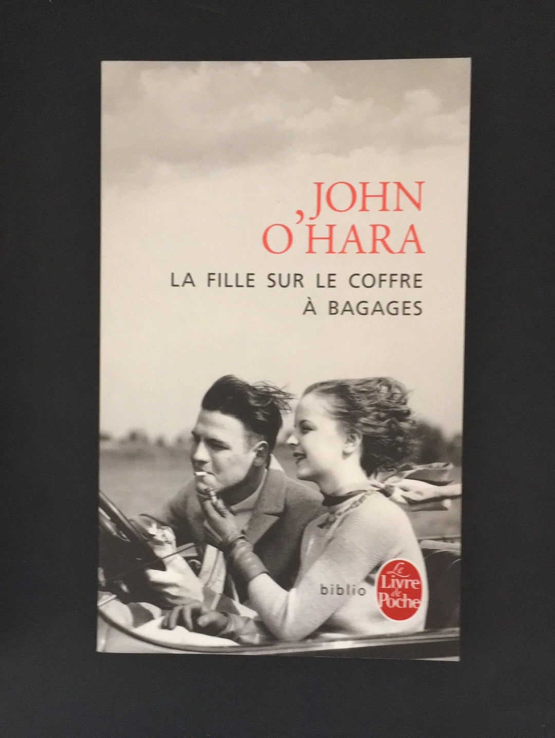LA FILLE SUR LE COFFRE À BAGAGES.